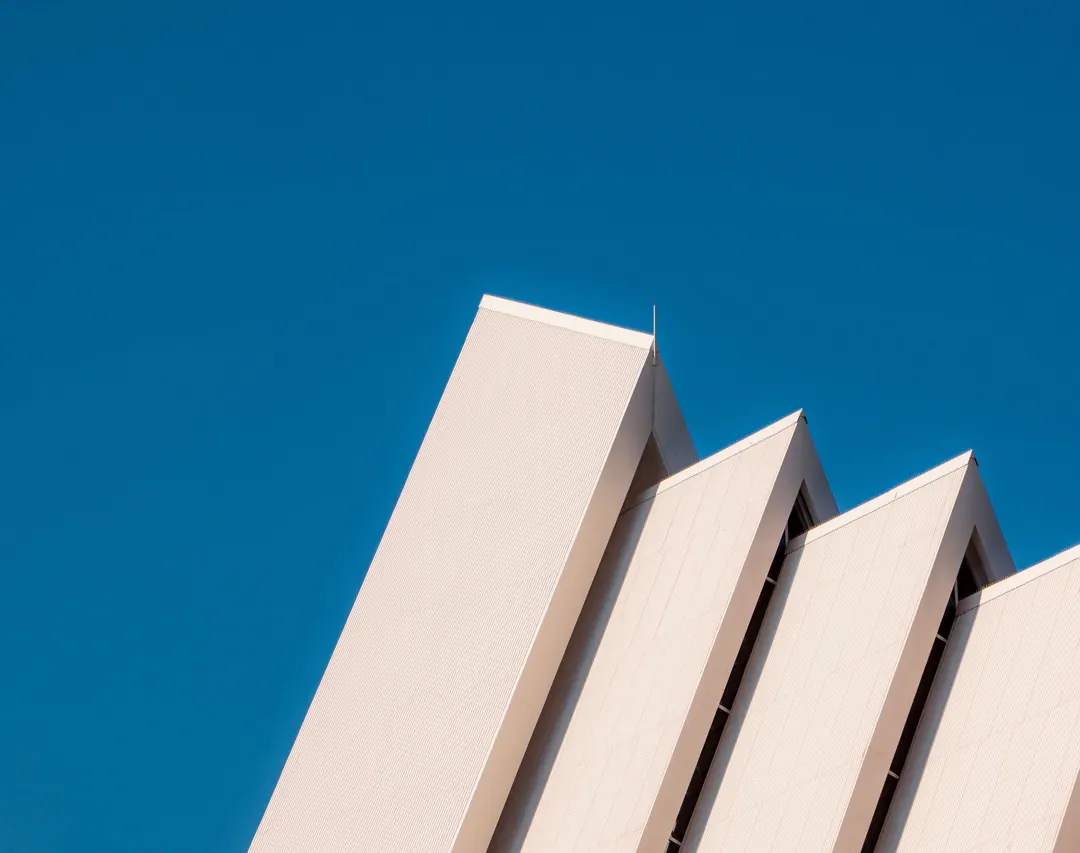 Angled concrete fins of a modern facade against a deep blue sky